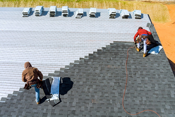 Roofer installing an asphalt shingle roof.