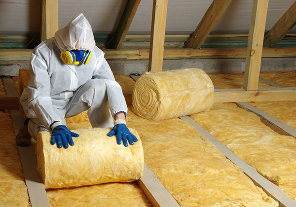 contractor installing insulation in attic