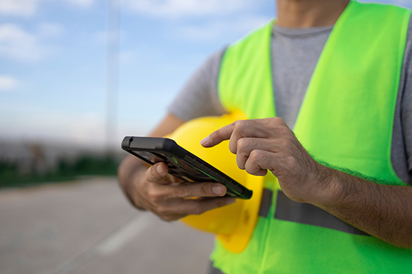 A contractor uses his mobile phone on a jobsite.