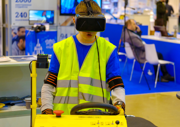 Boy using a VR headset and construction simulator at a convention.