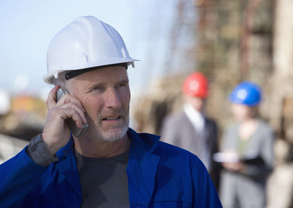 Worried contractor talking on a cell phone.