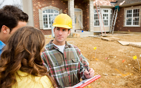 Clients communicating with contractor outside of a brick home