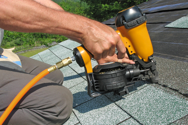 Roofing nail gun in use.