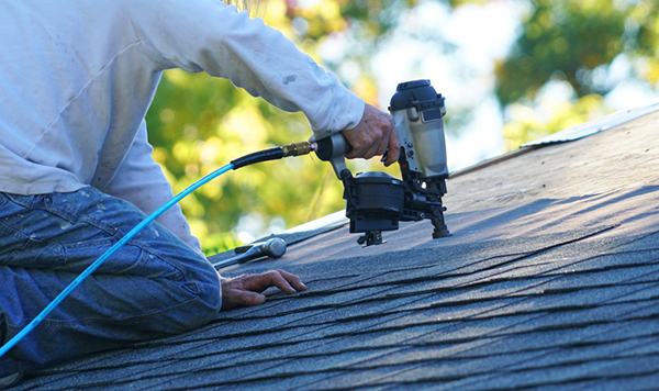 Contractor uses nail gun to replace shingles—common roofing mistakes