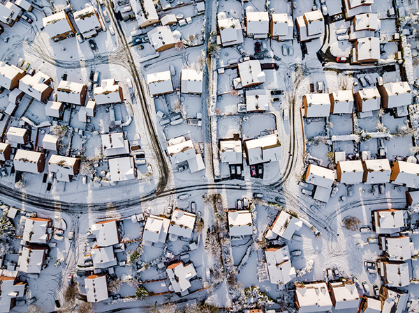 Aerial view of clusters of houses covered in a dusting of snow