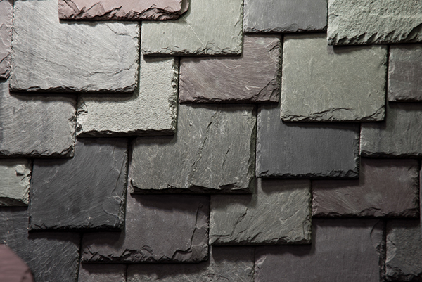 Layered slate roof tiles in varying shades of gray
